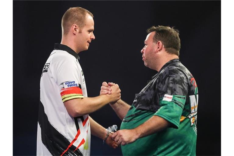 Max Hopp (l) gewann bei der Darts-WM sein Auftaktmatch gegen Gordon Mathers aus Australien. Foto: Kieran Cleeves/PA Wire/dpa
