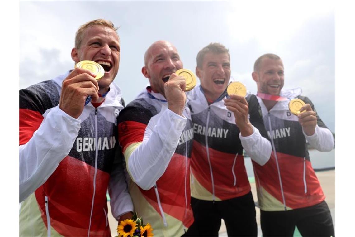 Max Rendschmidt, Ronald Rauhe, Tom Liebscher und Max Lemke feiern mit ihren Goldmedaillen. Foto: Jan Woitas/dpa