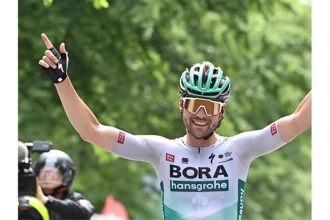 Schachmann zum zweiten Mal deutscher Straßenrad-Meister Maximilian Schachmann vom Team Bora hansgrohe fährt jubelnd über die Ziellinie. Foto: Bernd Weissbrod/dpa
