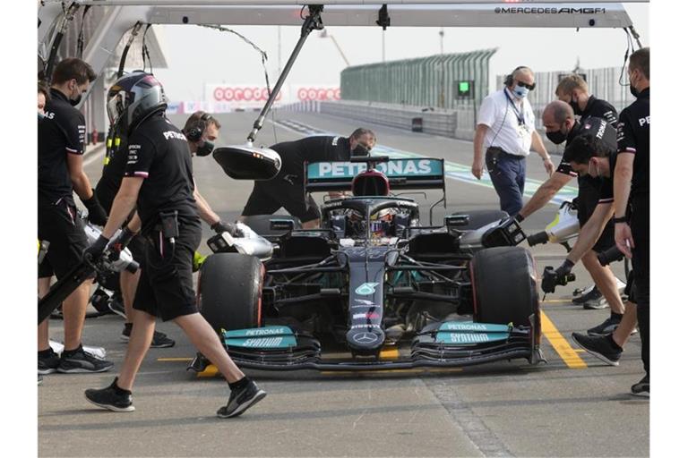 Mechaniker arbeiten bei einem Boxenstopps während des Trainings am Auto von Lewis Hamilton. Foto: Darko Bandic/AP/dpa