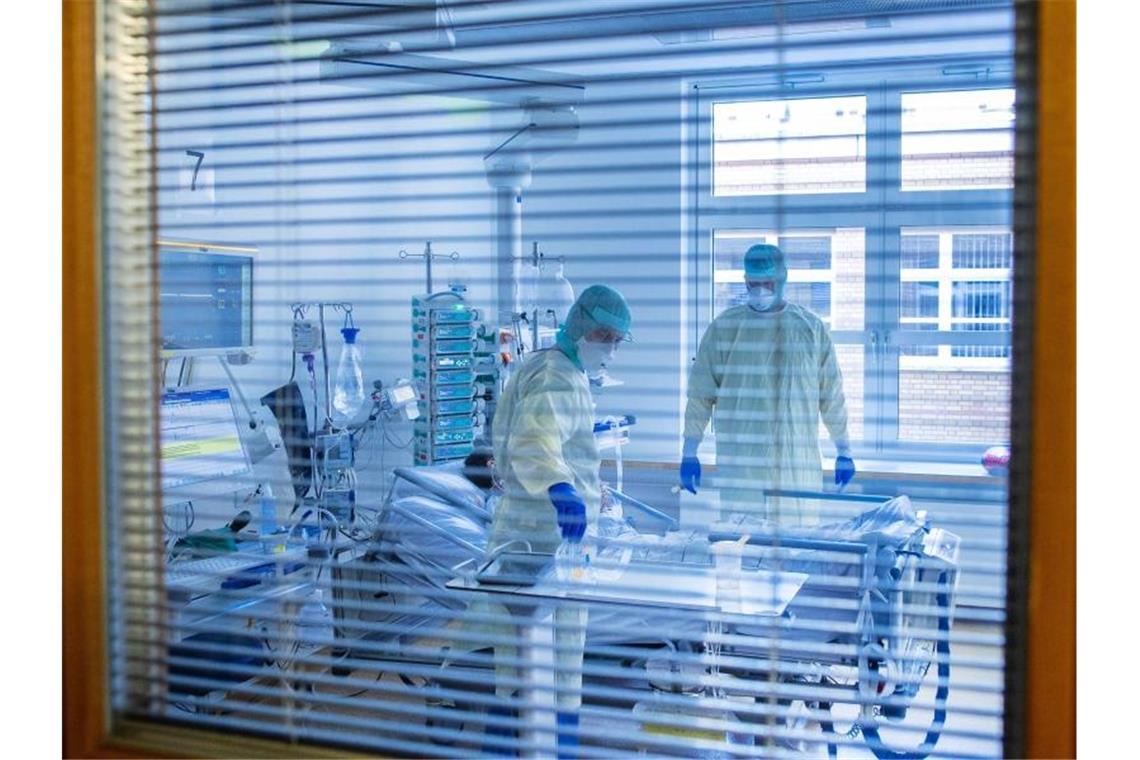 Jedes fünfte Intensivbett im Südwesten frei Mediziner und Pfleger versorgen einen an Covid-19 erkrankten Patienten in einem Zimmer. Foto: Jens Büttner/dpa-Zentralbild/dpa/archivbild