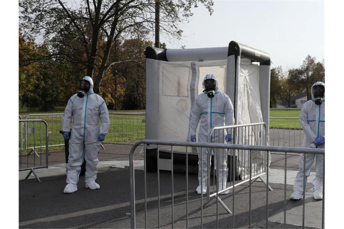 Medizinische Mitarbeiter der polnischen Armee bei der Arbeit in einer Drive-In-Teststation im Hauptquartier der Verteidigungstruppen in Zegrze. Foto: Pawel Supernak/PAP/dpa