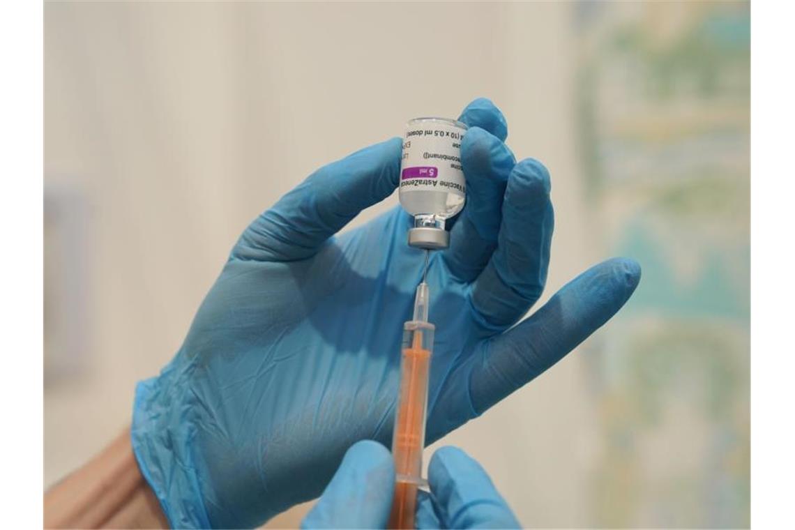Boostern mit Biontech oder Moderna? - „Nehmen, was da ist“ Medizinisches Personal befüllt eine Spritze mit dem Corona-Impfstoff von Oxford/Astrazeneca. Foto: Owen Humphreys/PA Wire/dpa