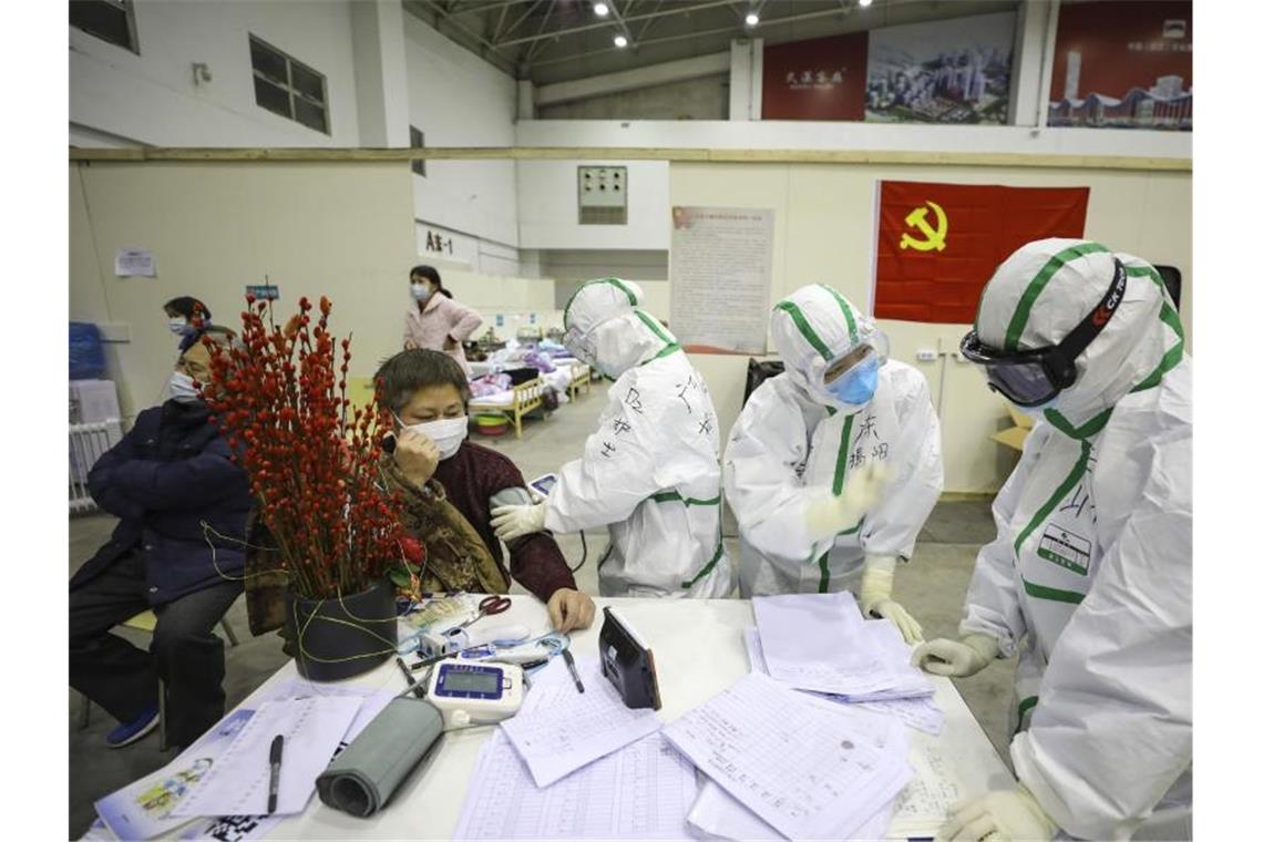 Medizinisches Personal betreut Patienten mit Symptomen des Coronavirus in einem provisorischen Krankenhaus in Wuhan. Foto: CHINATOPIX/AP/dpa