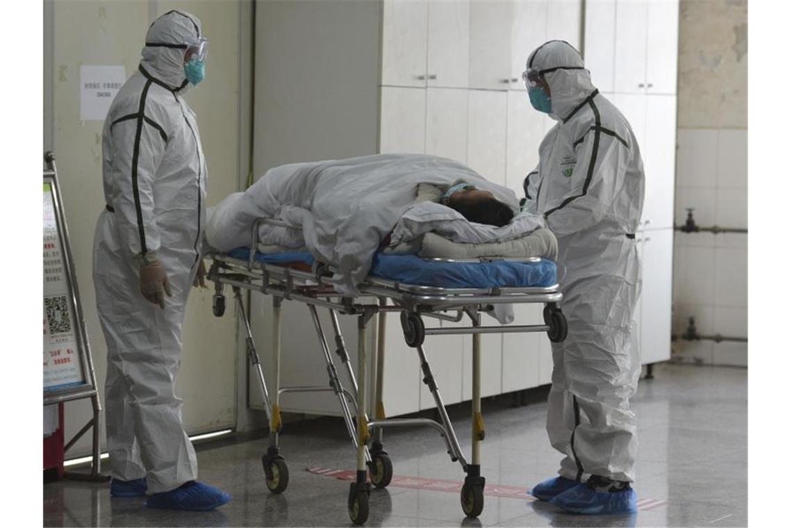 Medizinisches Personal in Schutzanzügen verlegt einen Coronavirus-Patienten in eine Isolierstation des Zweiten Volkskrankenhauses in der zentralchinesischen Provinz Anhui. Foto: Uncredited/CHINATOPIX/AP/dpa