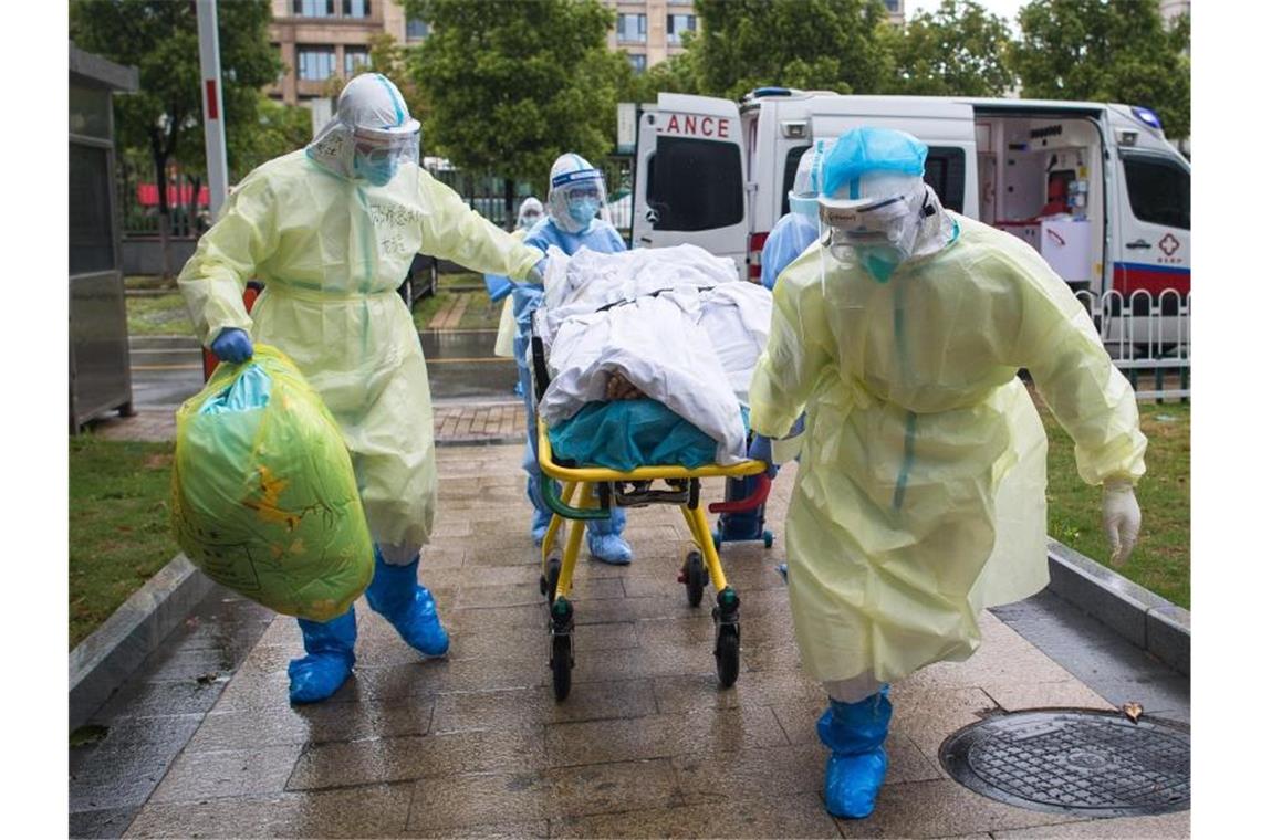 Medizinisches Personal in Wuhan rollt einen Patienten auf einer Liege in das Tongji-Krankenhauses. Foto: Xiao Yijiu/XinHua/dpa