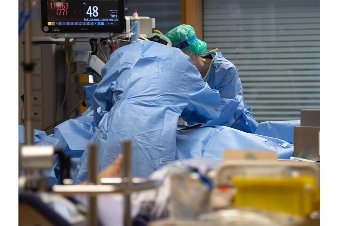 Medizinisches Personal legt auf einer Intensivstation einem Covid-19-Patienten einen Zugang für die künstliche Beatmung. Foto: Sebastian Gollnow/dpa