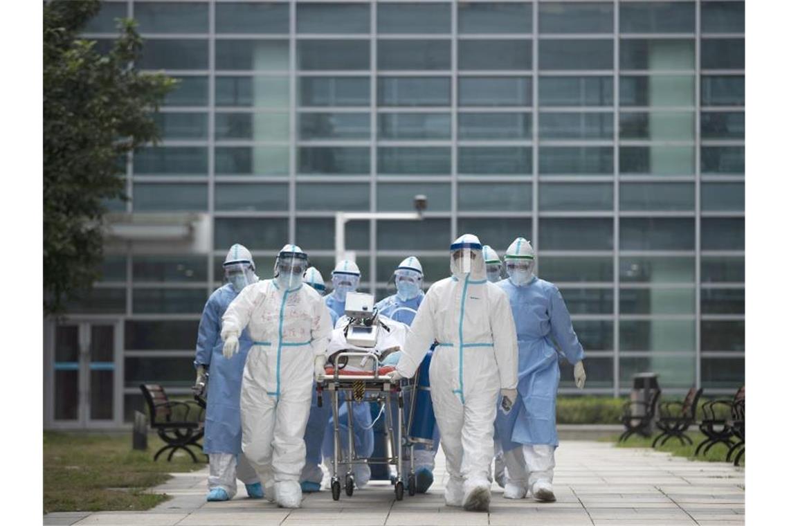 Medizinisches Personal mit einem Covid-19-Patienten im chinesischen Wuhan. Einer Studie zufolge entwickelten sich die Corona-Hotspots in Regionen mit ähnlichen Klimafaktoren. Foto: Fei Maohua/XinHua/dpa