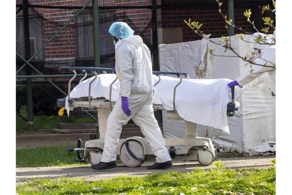 Forscher befürchten fast 300.000 Corona-Tote in den USA Medizinisches Personal transportiert eine Leiche aus einem Kühlwagen. Foto: Mary Altaffer/AP/dpa/Archiv