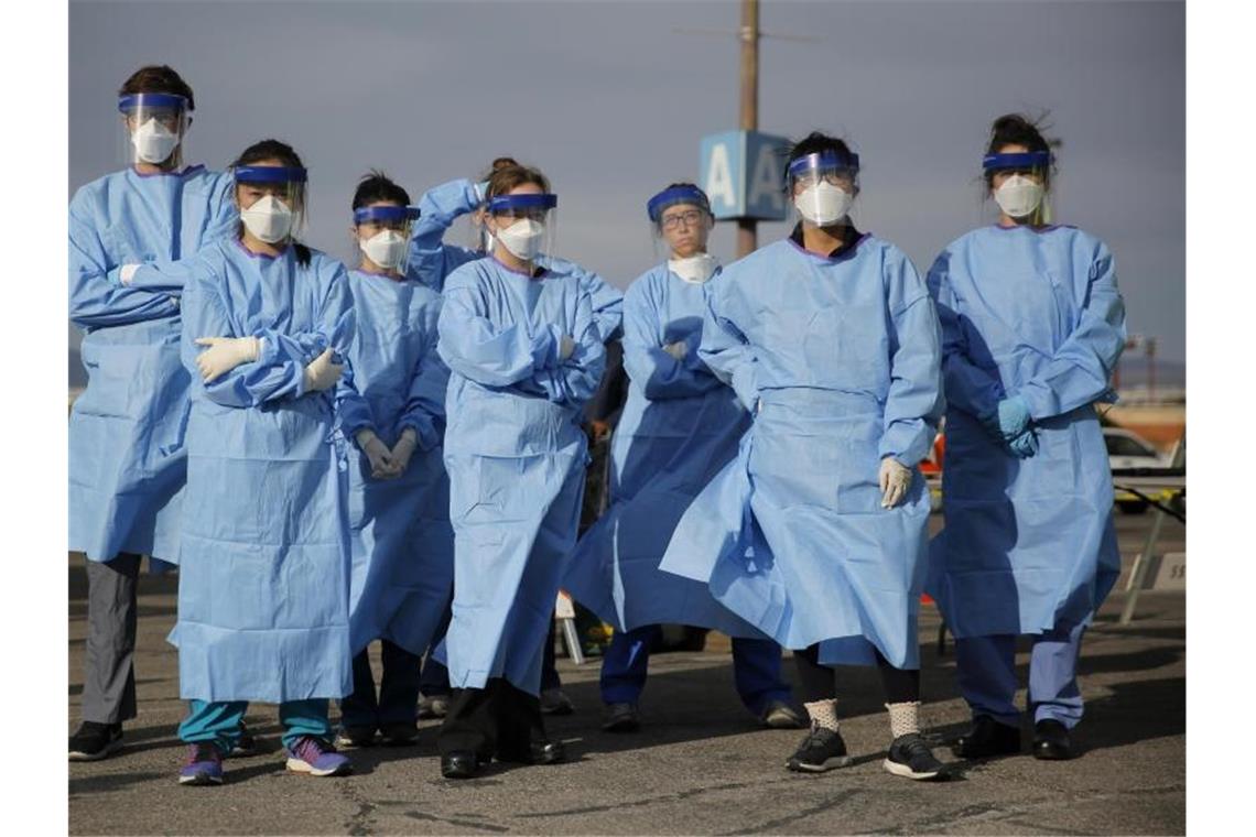 Trump bereitet USA auf dramatische Todeszahlen vor Medizinstudenten und Arzthelferinnen in Schutzkleidung stehen zusammen, bevor sie in einem Camp in Las Vegas Obdachlose auf eine mögliche Infizierung testen. Foto: John Locher/AP/dpa