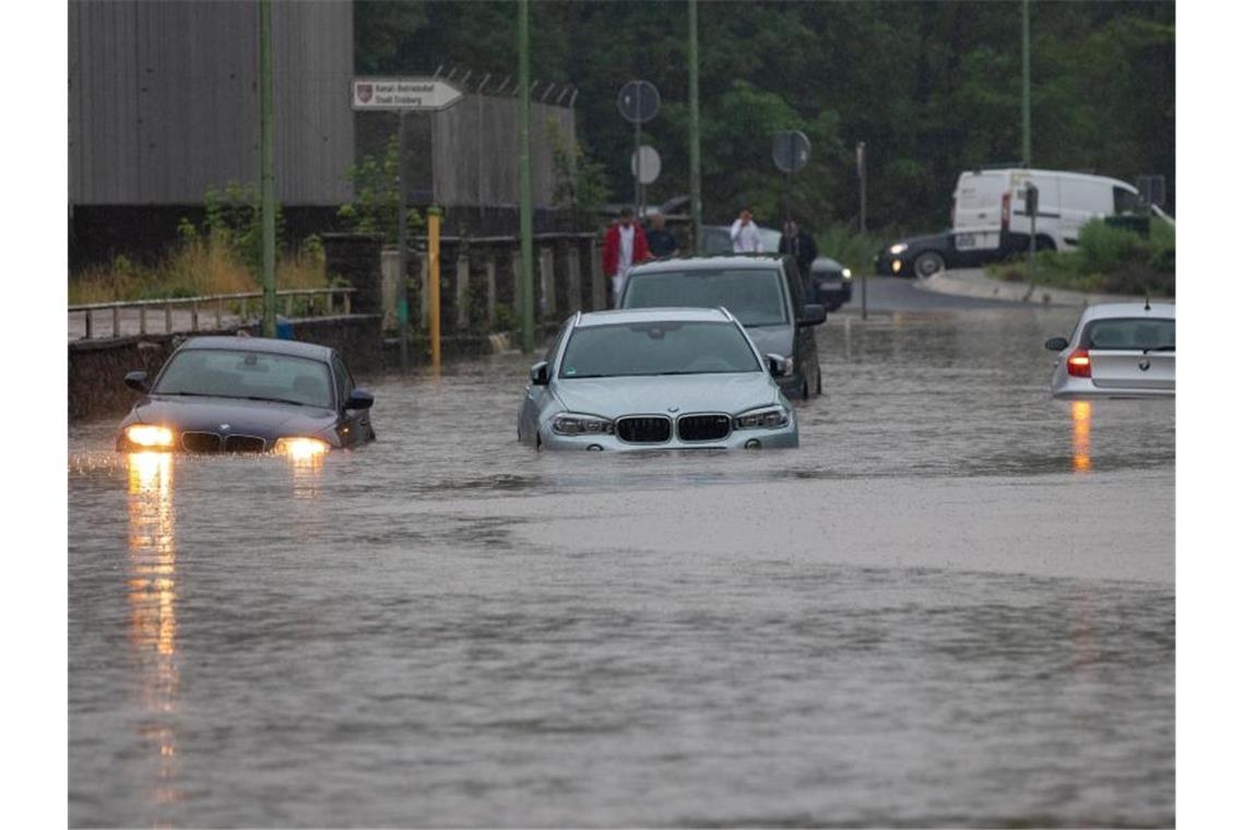 Mehrere Autos stecken nach Starkregen auf einer überfluteten Straße in Stolberg in NRW fest. Der Bach Vicht war über die Ufer getreten. Foto: Ralf Roeger/dmp Press/dpa
