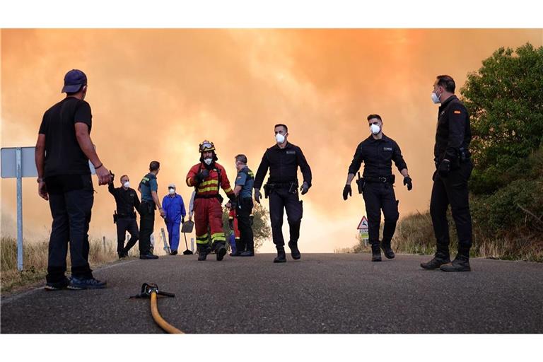 Mehrere Einsatzkräfte versuchen ein Feuer in Anllarinos del Sil in Spanien zu löschen.