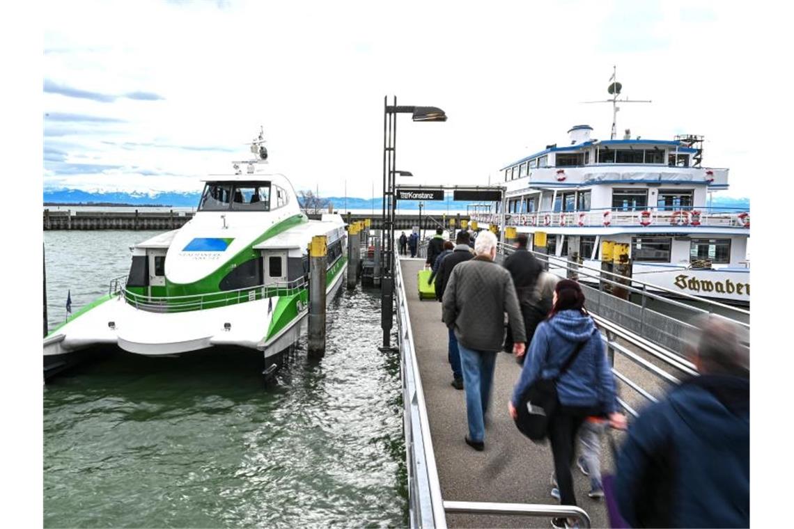 Vorerst kein Halbstundentakt für Fährverbindung am Bodensee Mehrere Fußgänger laufen auf der Mole zu einer Fähre. Foto: Felix Kästle/dpa/Symbolbild