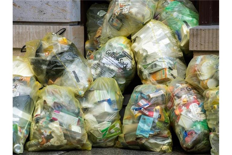 Mehrere gelbe Säcke auf einem Fußweg vor einem Haus in Hamburg. Foto: Robert Michael/dpa-Zentralbild/dpa