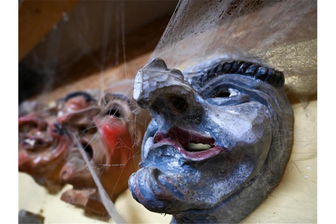 Verstaubte Masken und Online-Bälle: Fastnacht mit Corona Mehrere hölzerne Narrenmasken hängen in der Werkstatt von Masken- und Holzschnitzer Jogi Weiß. Foto: Felix Kästle/dpa