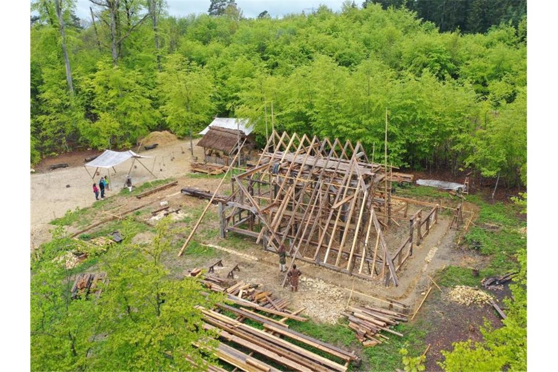 Mehrere Holzhandwerker arbeiten an einer Scheune am „Campus Galli“. Foto: Felix Kästle/dpa