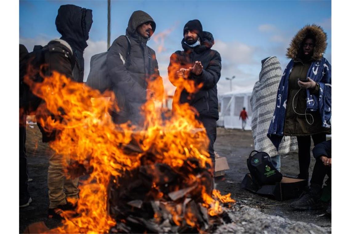 Auf der Flucht: Lange Wartezeiten an den Grenzen Mehrere Menschen wärmen sich an einem Feuer am Grenzübergang zwischen Polen und der Ukraine. Foto: Alejandro Martínez Vélez/EUROPA PRESS/dpa
