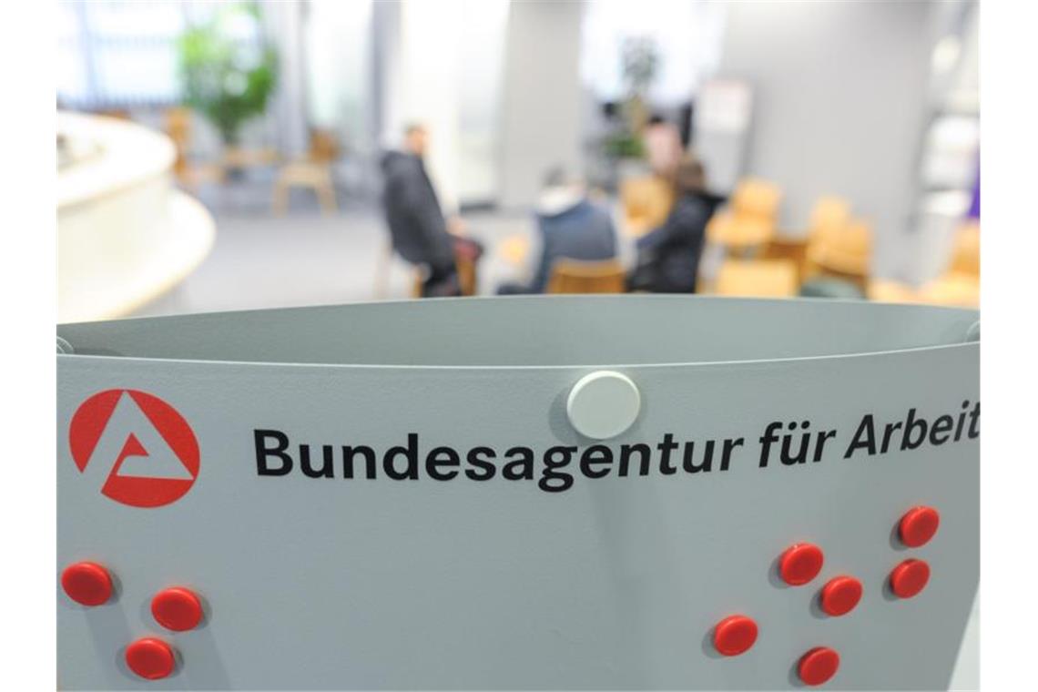 Mehrere Personen sitzen im Wartebereich der Bundesagentur für Arbeit in Stuttgart. Foto: Larissa Schwedes/dpa