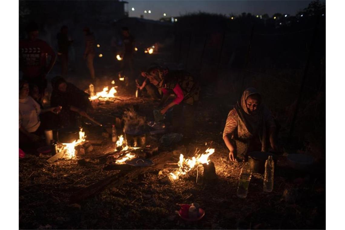 UN-Chef: Migranten von Lesbos aufs Festland bringen Mehrere Tausend Migranten haben die dritte Nacht unter freiem Himmel verbracht, nachdem zwei aufeinanderfolgende Nächte mit Bränden in dem überfüllten Lager Moria sie obdachlos gemacht hatten. Foto: Petros Giannakouris/AP/dpa
