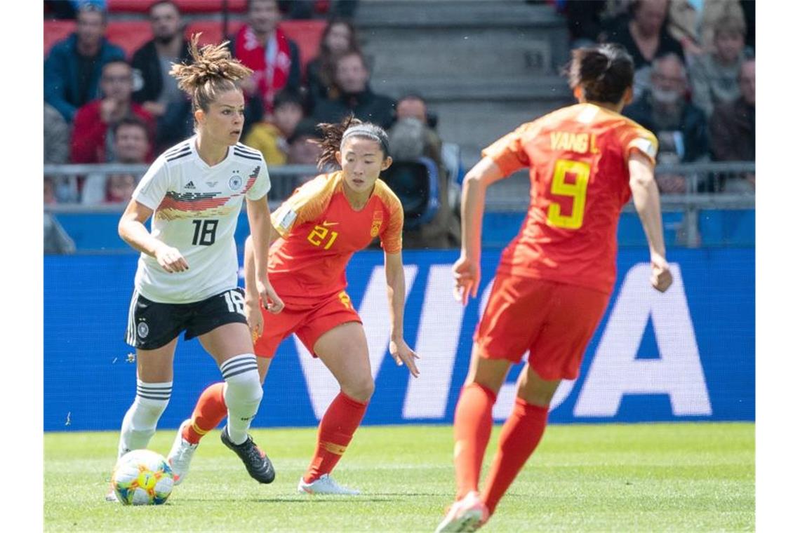 Zitterstart mit Happy End: DFB-Elf beklagt Chinas Härte Melanie Leupolz (l) schirmt den Ball erfolgreich vor Wei Yao (M) ab. Foto: Sebastian Gollnow