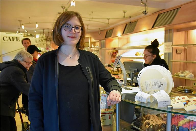 Melanie Weller, die Schwiegertochter von Sibylle Weller, zeigt den Plastikeimer, in dem im Café Weller die Bons für Brezeln, Brötchen und Co. gesammelt werden, die die Kunden nicht mitnehmen möchten. Foto: T. Sellmaier