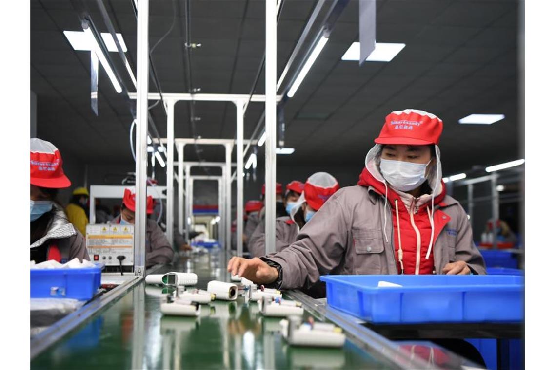 Menschen arbeiten in einer chinesischen Fabrik am Fließband. Seit Jahren verhandeln die EU und China über einen faireren Wettbewerb. Foto: Xue Yuge/XinHua/dpa