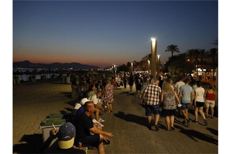 Menschen auf der abendlichen Strandpromenade von Palma de Mallorca. Foto: Clara Margais/dpa