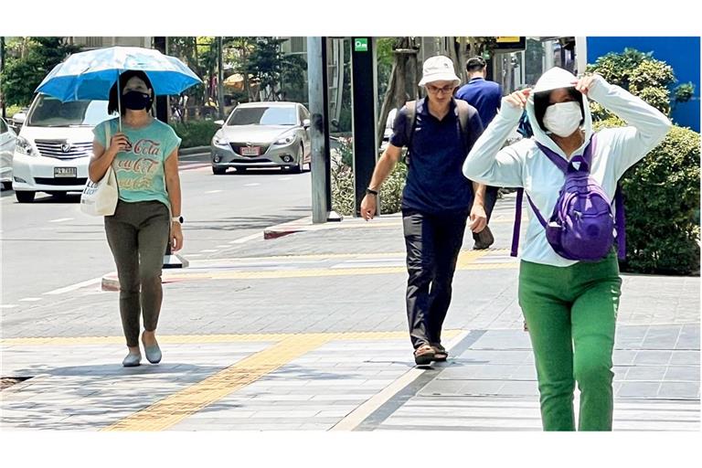 Menschen auf der Silom Road in Bangkok versuchen, sich vor der Hitze zu schützen.