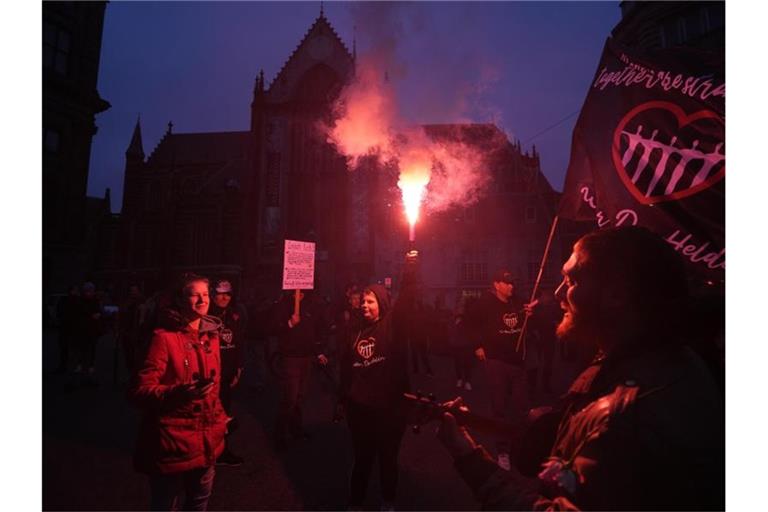 Menschen bei einer Demonstration gegen die Covid-19-Beschränkungen in Amsterdam teil. Nach den heftigen Ausschreitungen in Rotterdam haben Randalierer in verschiedenen Städten der Niederlande für Unruhen gesorgt. Foto: Peter Dejong/AP/dpa