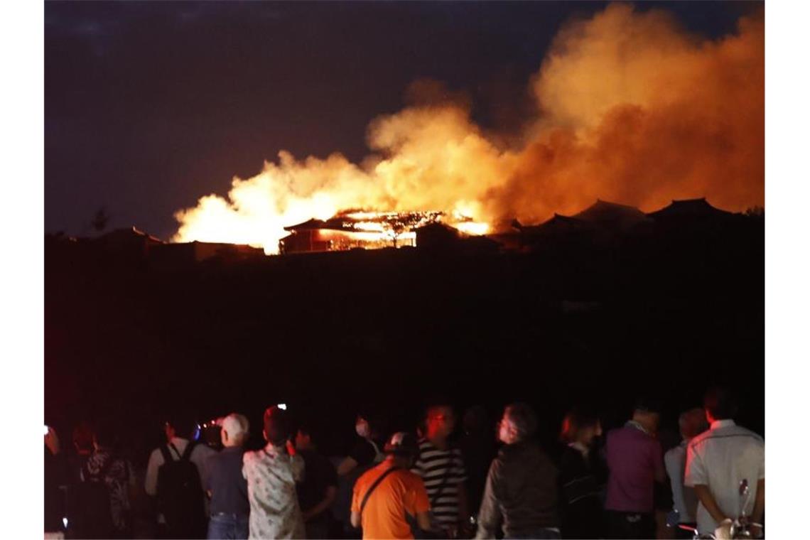 Menschen beobachten den Brand der historischen Shuri Burg. Foto: Jun Hirata/Kyodo News/AP/dpa