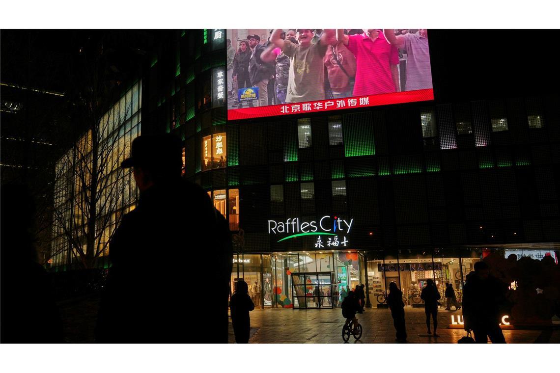 Menschen beobachten in China eine Übertragung einer Kundgebung aus Caracas.