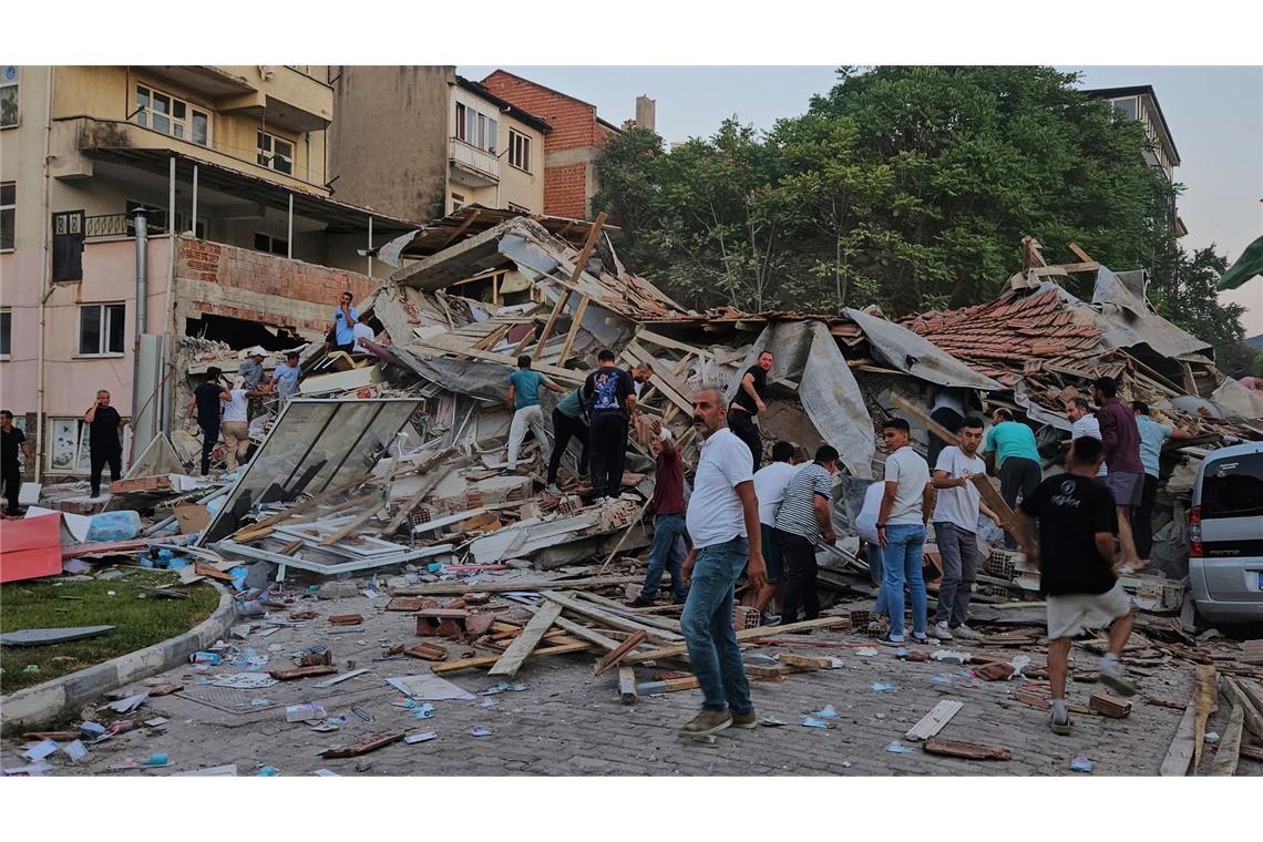 Erdbeben der Stärke 6,1 – mindestens ein Toter und 29 Verletzte Menschen beseitigen die Trümmer eines eingestürzten Gebäudes nach einem Erdbeben in Sindirgi in der Westtürkei.