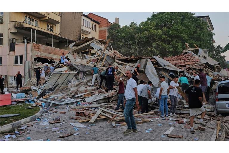 Menschen beseitigen die Trümmer eines eingestürzten Gebäudes nach einem Erdbeben in Sindirgi in der Westtürkei.