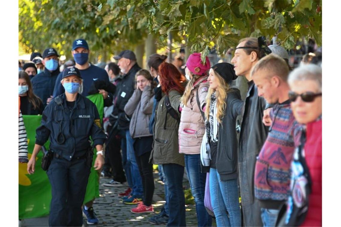 Für und gegen Corona-Politik: Demo-Wochenende am Bodensee Menschen bilden eine sogenannte Friedensmenschenkette, die durch Deutschland, Österreich, Liechtenstein und die Schweiz rund um den Bodensee führen soll. Foto: Felix Kästle/dpa