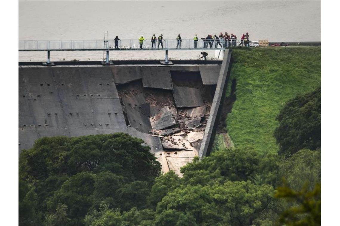 Menschen bilden über dem beschädigter Teil eines Staudamms am Toddbrook Reservoir nahe Whaley Bridge eine Menschenkette, um Sandsäcke auszulegen. Foto: Danny Lawson/PA Wire