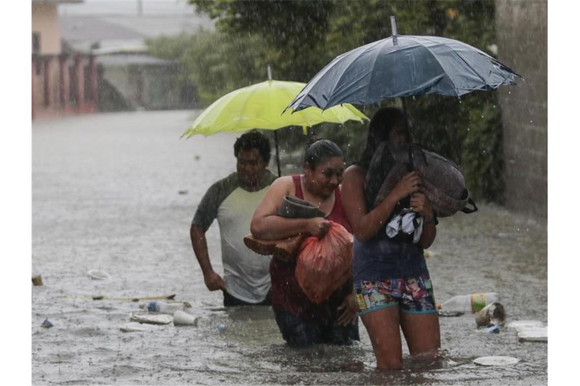 Menschen bringen sich in Sicherheit. Aufgrund des Tropensturms „Eta“ wurden in Honduras Überschwemmungen und Erdrutsche gemeldet. Etwa 30 Ortschaften wurden von der Außenwelt abgeschnitten, weil Brücken einstürzten. Foto: Delmer Martinez/AP/dpa