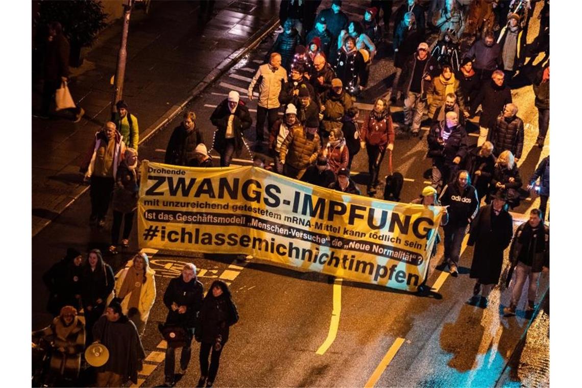 Silvester in Baden-Württemberg: Keine Partys, dafür Demos Menschen demonstrieren am Silvesterabend in Stuttgart gegen die Corona-Politik. Foto: Christoph Schmidt/dpa