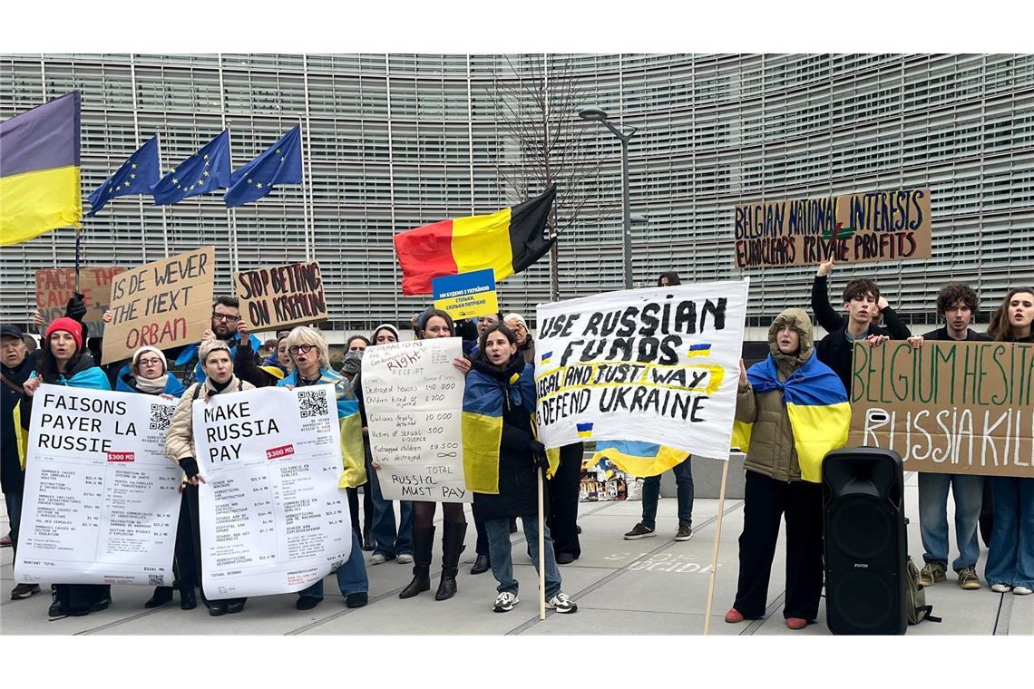 Menschen demonstrieren vor dem EU-Ratsgebäude für die Verwendung von in der EU festgesetztem russischen Geld für die Ukraine.