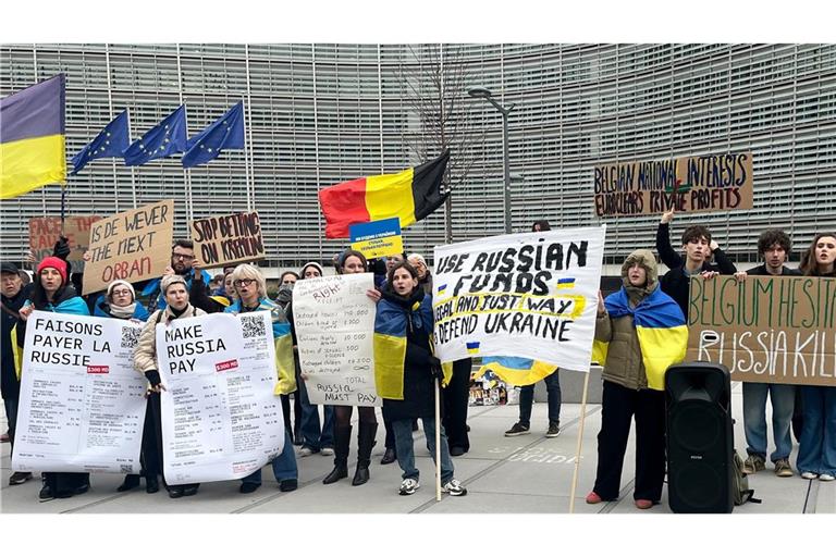 Menschen demonstrieren vor dem EU-Ratsgebäude für die Verwendung von in der EU festgesetztem russischen Geld für die Ukraine.