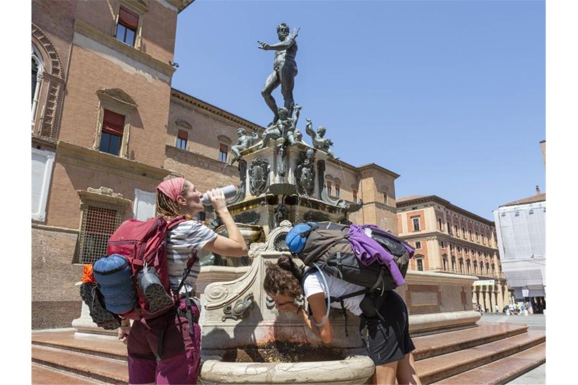 Menschen erfrischen sich an einem Brunnen in Bologna. Foto: Guido Calamosca/LaPresse/AP/dpa