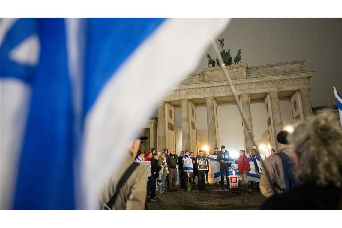 Menschen erinnern am Brandenburger Tor an die Opfer des 7. Oktober.