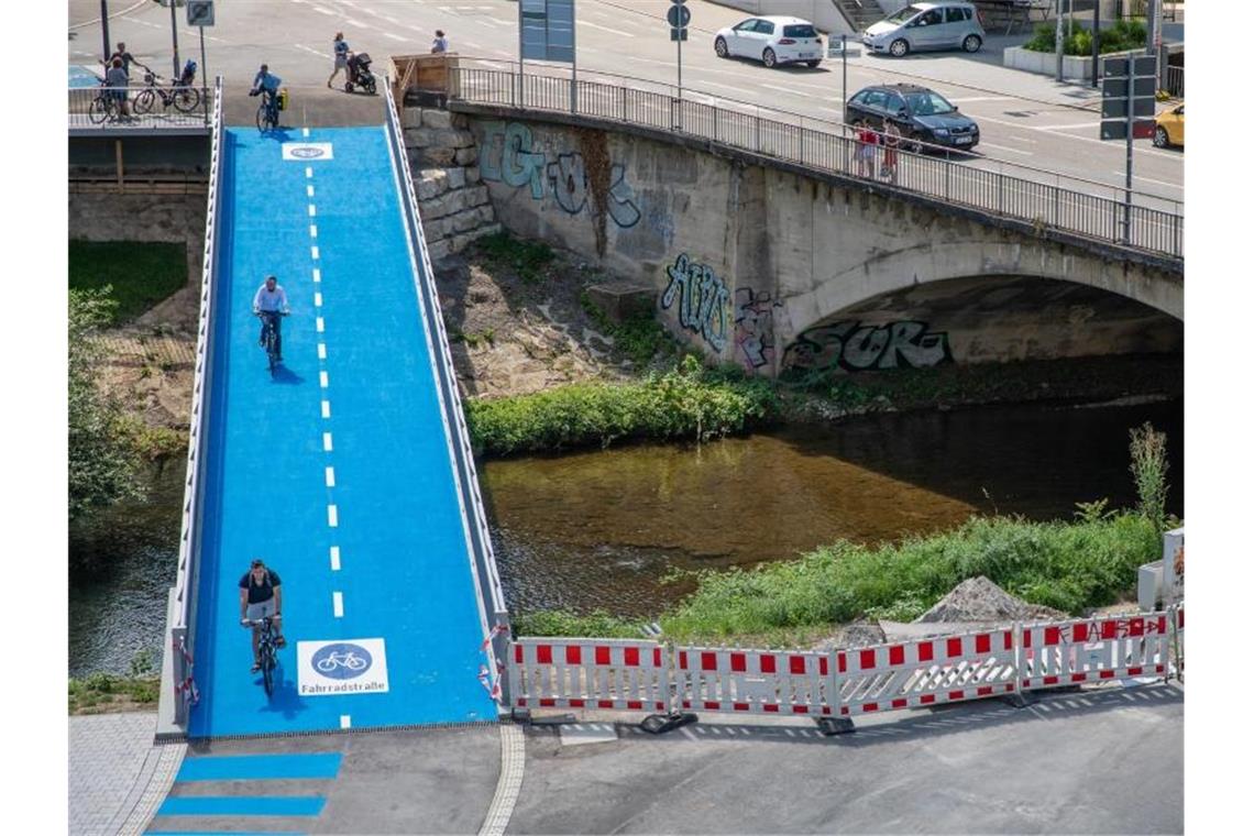 Weiterer Bau einer beheizbaren Brücke in Tübingen startet Menschen fahren mit ihren Fahrrädern über eine beheizbare Radbrücke. Foto: Christoph Schmidt/dpa/Archivbild