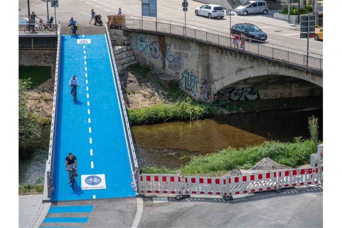 Menschen fahren mit ihren Fahrrädern über eine beheizbare Radbrücke. Foto: Christoph Schmidt/dpa/Archivbild