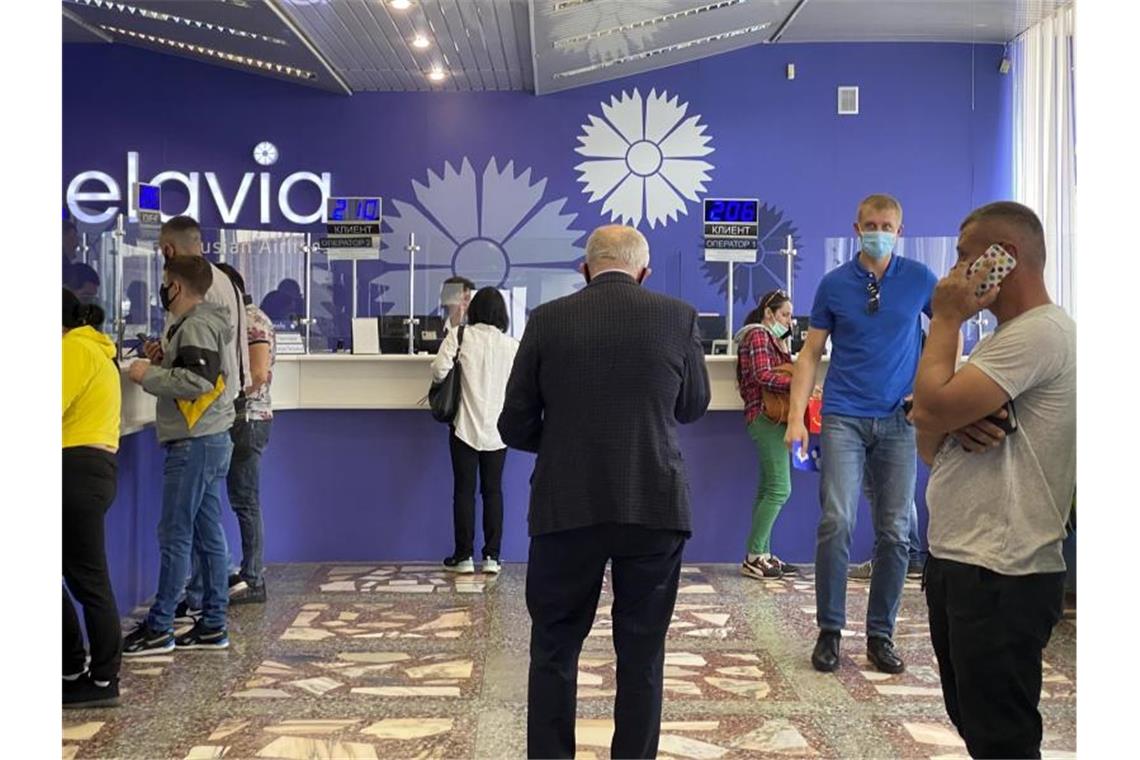 Russland hilft Lukaschenko mit neuem Kredit Menschen geben ihre Tickets für Auslandsflüge in einem Büro von Belavia, der staatlichen belarussischen Fluggesellschaft, zurück. Foto: Uncredited/AP/dpa