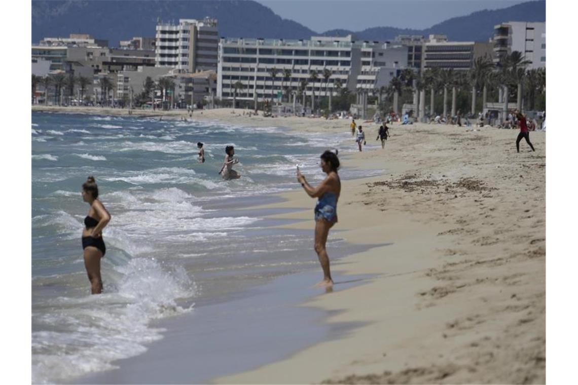 Balearen-Präsidentin: Nachtleben eher erst nach dem Sommer Menschen gehen am Strand von Arenal schwimmen. Foto: Clara Margais/dpa