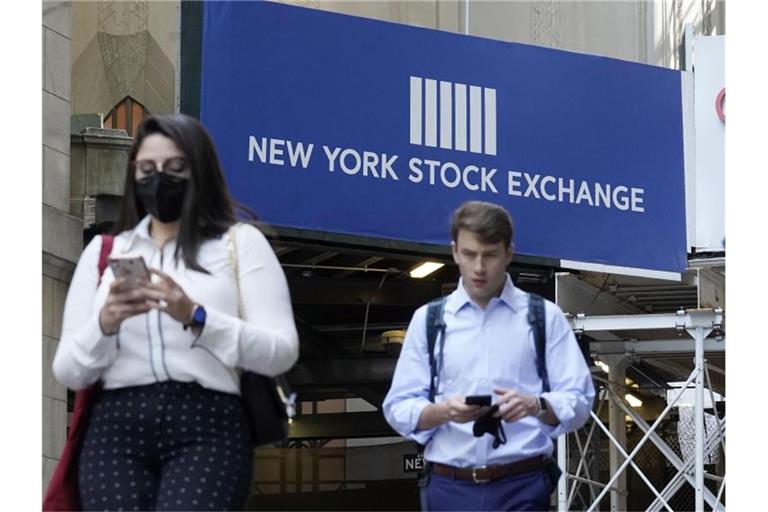 Menschen gehen an einem Eingang des New York Stock Exchange vorbei. Die US-Börsen können sich der weltweiten Marktschwäche nicht entziehen. Foto: Richard Drew/AP/dpa