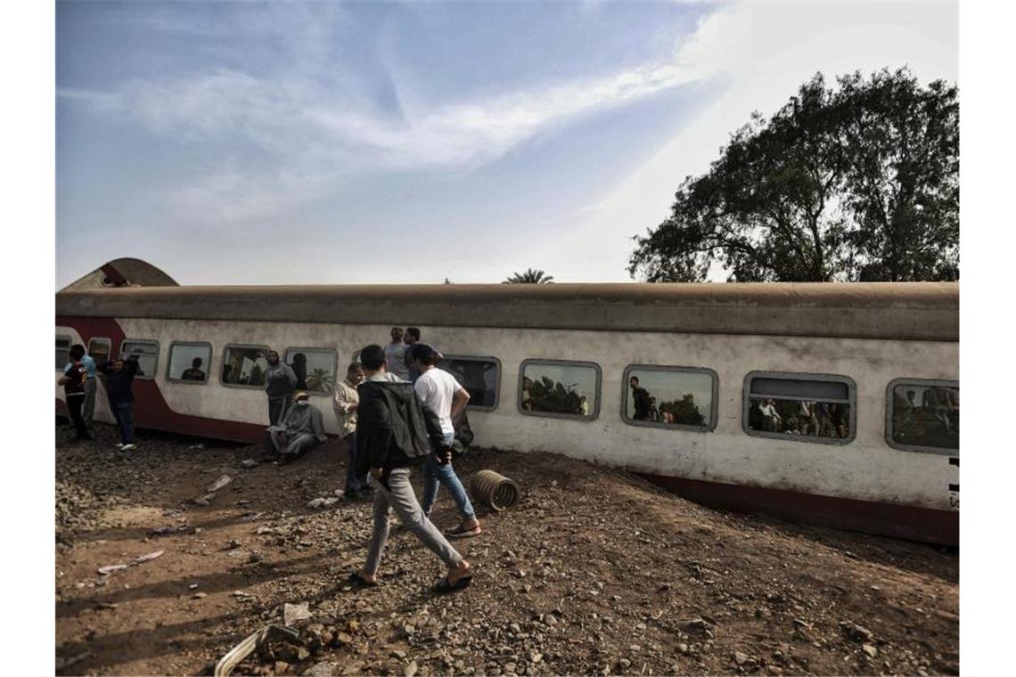 Erneut Zugunglück in Ägypten - mehrere Tote Menschen gehen an einem entgleisten Waggon in der Provinz Kaljubia vorbei. Foto: Sayed Hassan/dpa