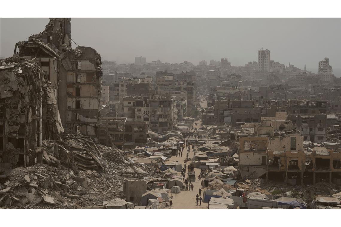 Menschen gehen auf zerstörter Straße im Gazastreifen. (Archivbild)