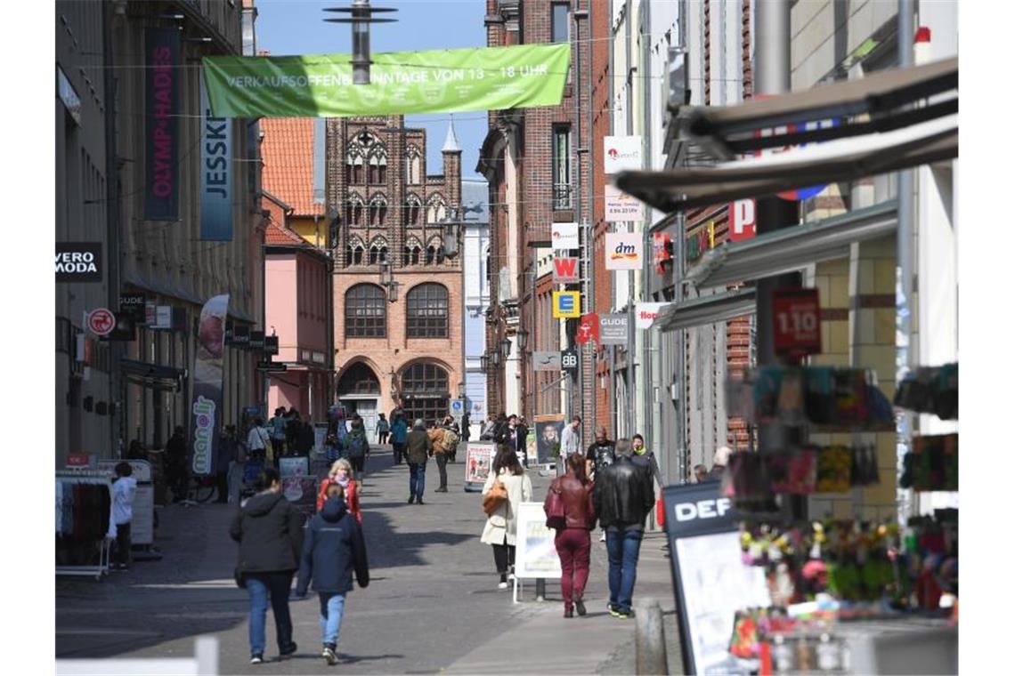 Menschen gehen durch die Einkaufstraße im Zentrum von Stralsund. Foto: Stefan Sauer/dpa-Zentralbild/dpa