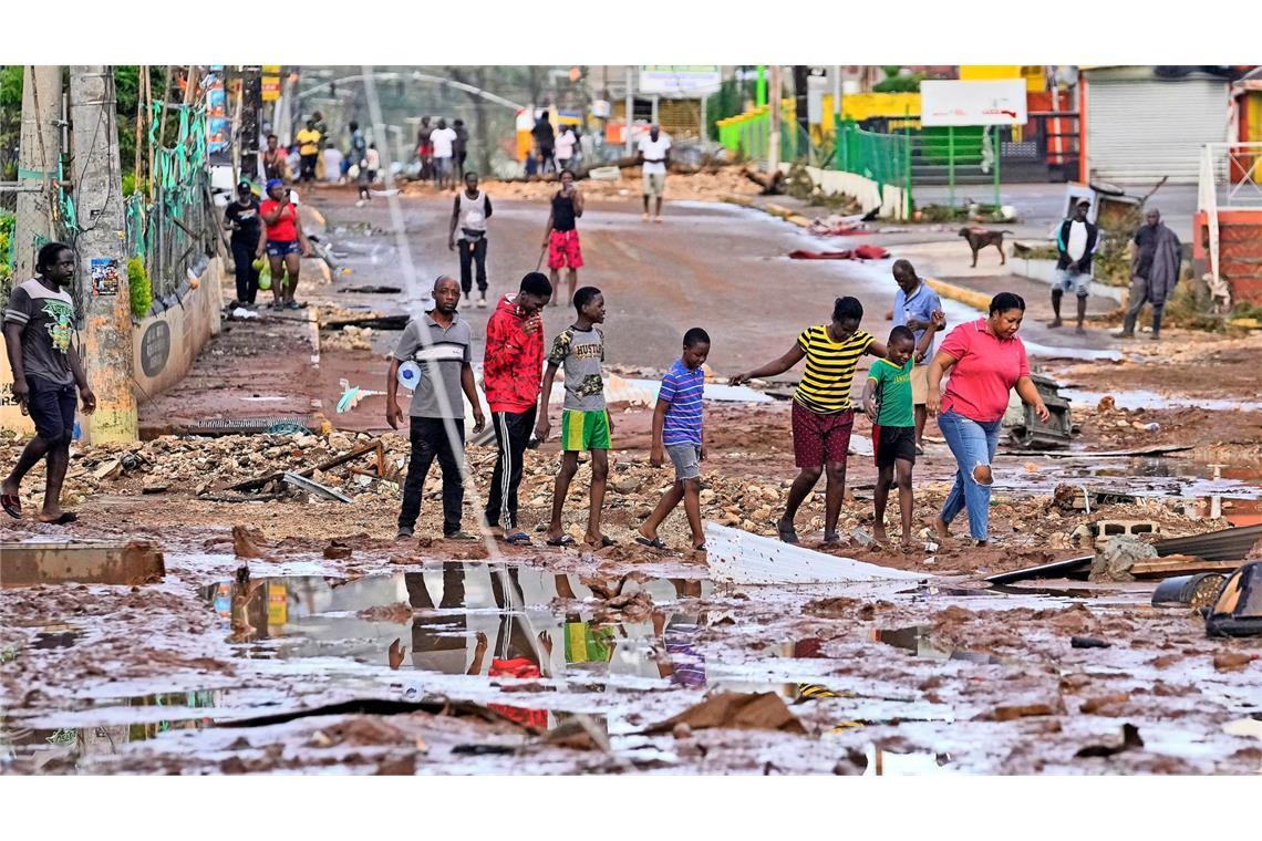 Menschen gehen nach dem Durchzug von Hurrikan «Melissa» durch Santa Cruz.